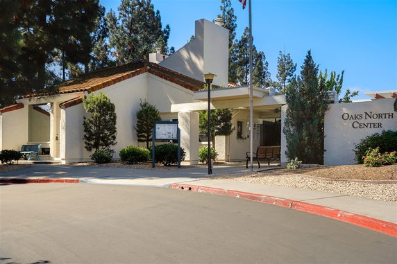 Front view of a building named Oaks North Center with a pathway and landscaped area.