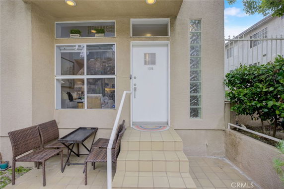 Front entryway of a house with a white door and decorative glass block window.