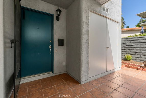 Front view of a house with a blue door and adjacent storage compartment.