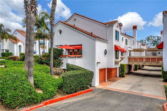 Front view of a multi-story house with a red-tiled roof and red awnings.