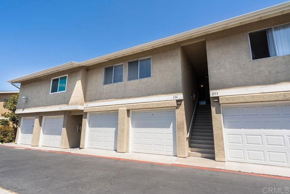 Front view of a multi-family building with garages on the ground floor.