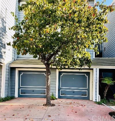Front view of a house with a double garage and a tree in the driveway.
