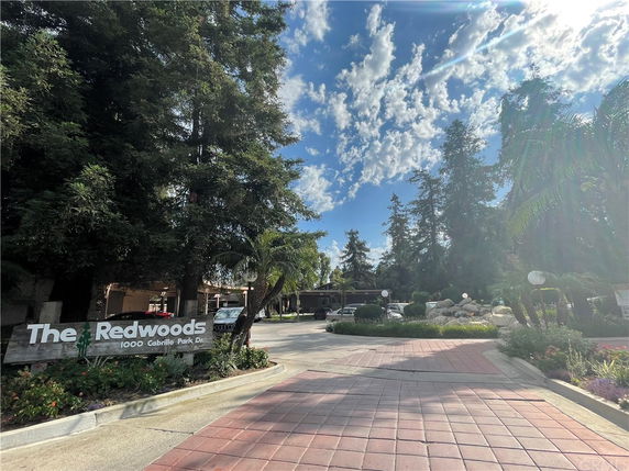 Front view of a building entrance with a sign reading 'The Redwoods'.