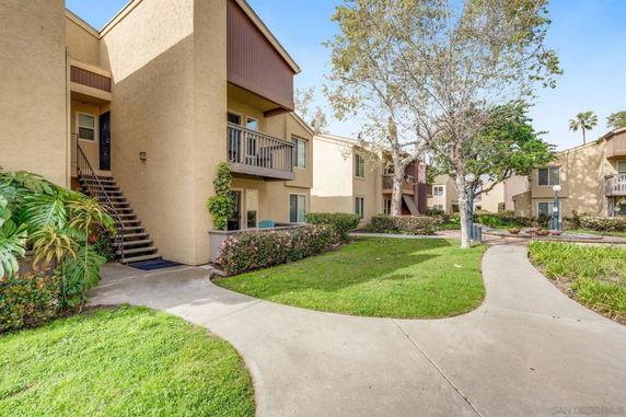 Front view of a two-story residential building with balconies and exterior staircases.