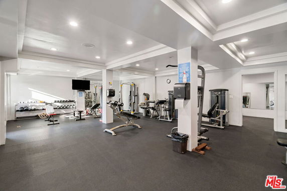 Indoor gym area with various exercise equipment and weights.