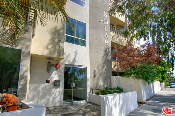 Front view of a modern multi-story building with large windows and a sign reading 'SOLARIS'.