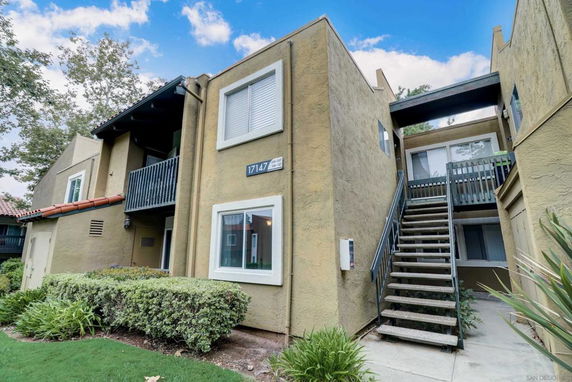 Front view of a two-story apartment building with external stairs.