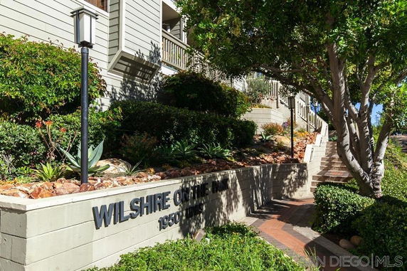 Front view of a building with stairs and landscaped garden.
