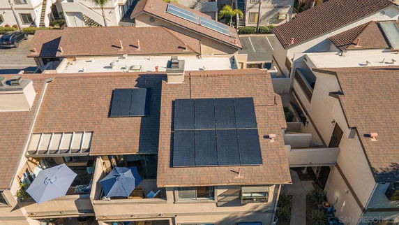 Aerial view of rooftop equipped with solar panels on residential buildings.