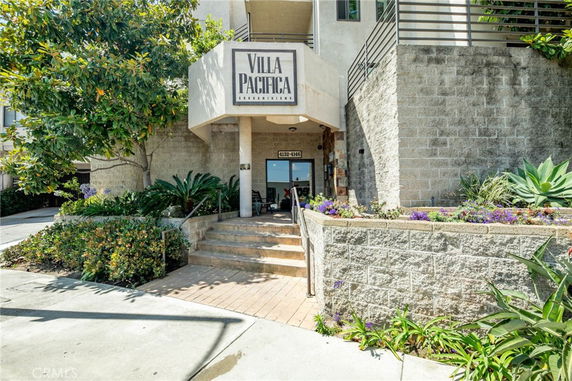 Front view of a condominium entrance with stairs and sign reading 'Villa Pacifica'.
