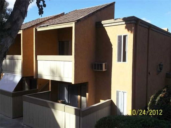 Front view of a two-story building with balconies and a slanted roof.