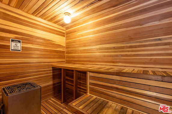 Interior view of a wooden sauna room with benches and a heater.