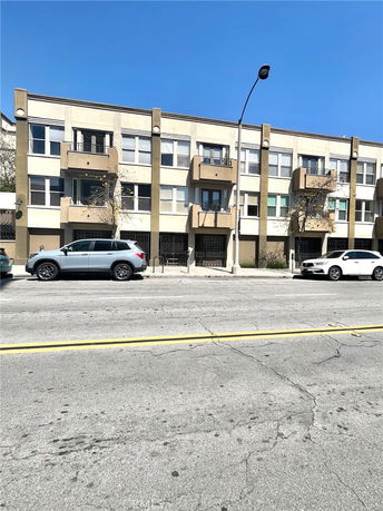 Front view of a three-story apartment building with balconies.