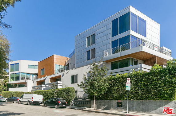 Front view of modern, multi-story residential buildings with large windows and balconies.