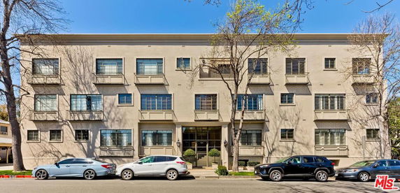 Front view of a three-story apartment building with multiple windows and a central entrance.