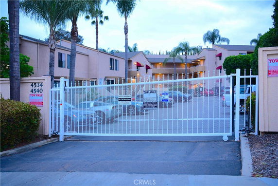 Gated entrance to residential area with visible parking lot