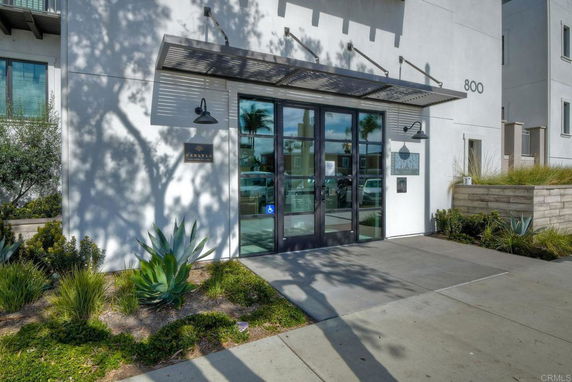 Front view of a building entrance with glass doors and a metal awning.