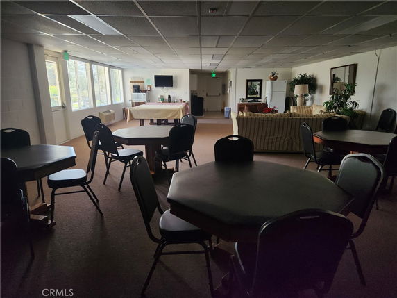 Interior view of a recreational room with tables, chairs, and a seating area.