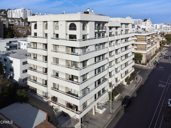 Front view of a multi-story apartment building with balconies on each floor.
