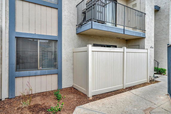 View of a building with balcony and fenced area.