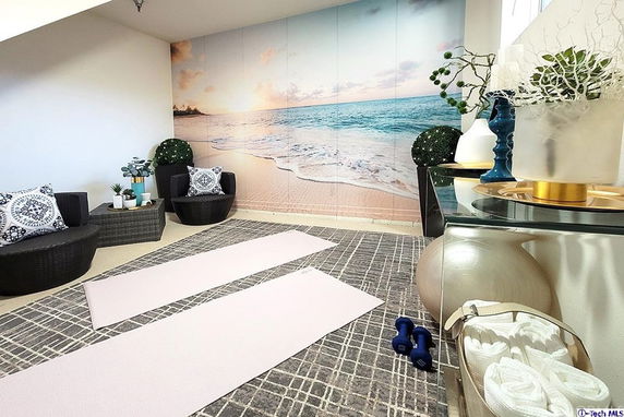 Indoor club house area with yoga mats and beach-themed wall mural.