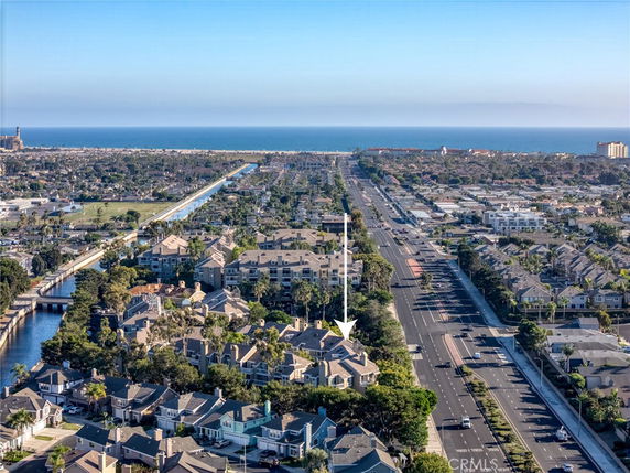 Panoramic view overlooking a residential area with roads and coastline in the distance.