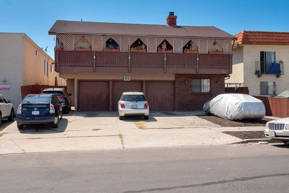 Front view of a two-story building with garages and a balcony.