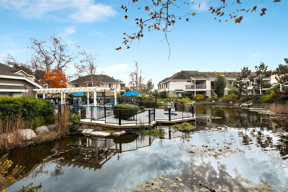 Outdoor view of residential buildings surrounding a serene water area.