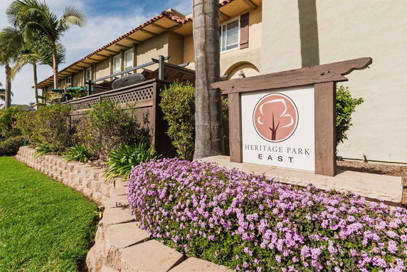Front view of a two-story building with a landscaped garden and a sign reading 'Heritage Park East'.