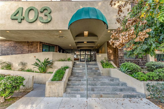 Front view of a building entrance with large numbers '403' on the facade and a covered entrance canopy.