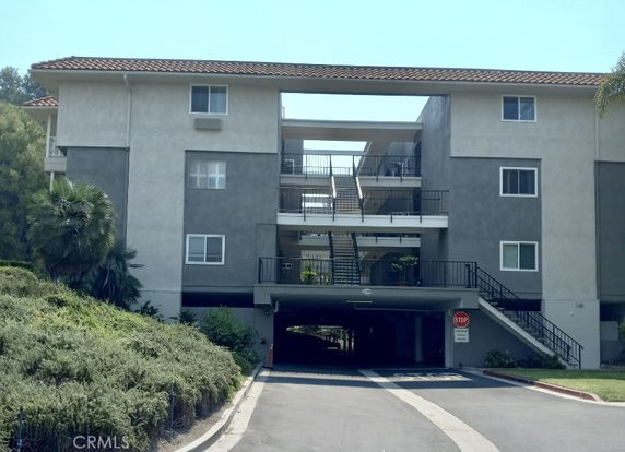 Front view of a multi-story apartment building with a central open stairway.