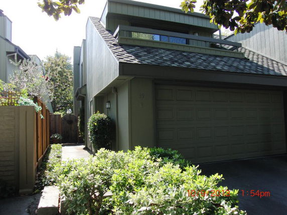 Front view of a two-story house with a garage and balcony.