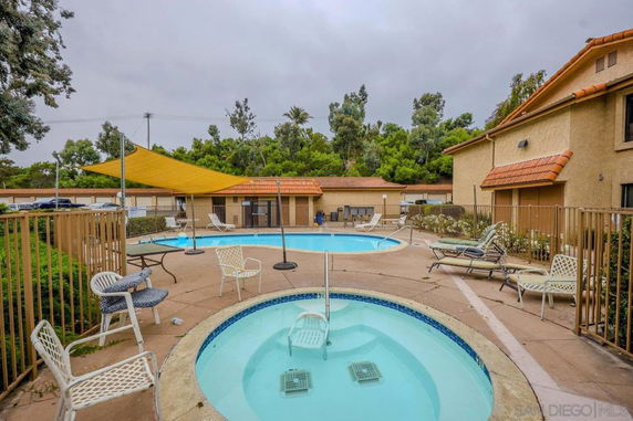 Outdoor swimming and spa area with patio furniture.