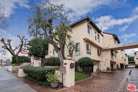 Front view of a multi-story residential building with a connected archway.