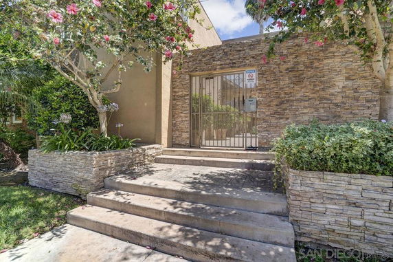 Front view of a building entrance with stone facade and gated entry.