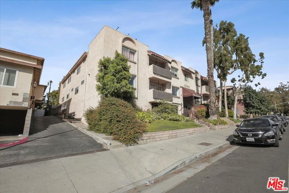 Front view of a multi-story apartment building with balconies.