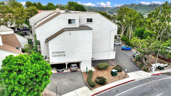 Front view of Mission Heights building with a parking area underneath.