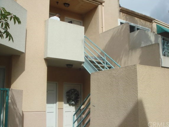 Front view of a two-story building with external stairs and balconies.