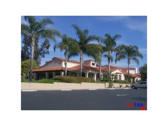Front view of a large house with red tile roof and multiple gables.