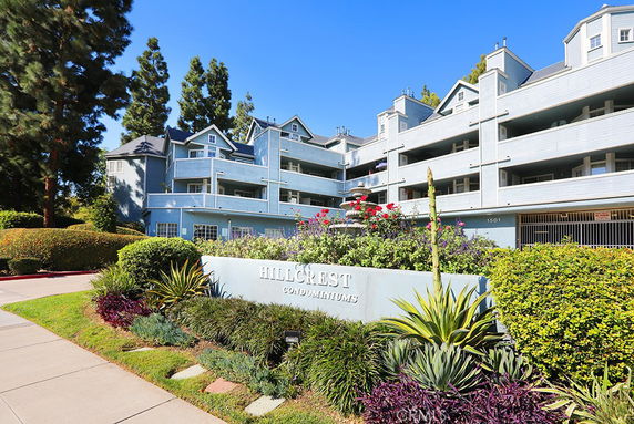 Front view of a multi-story condominium building with blue exterior.