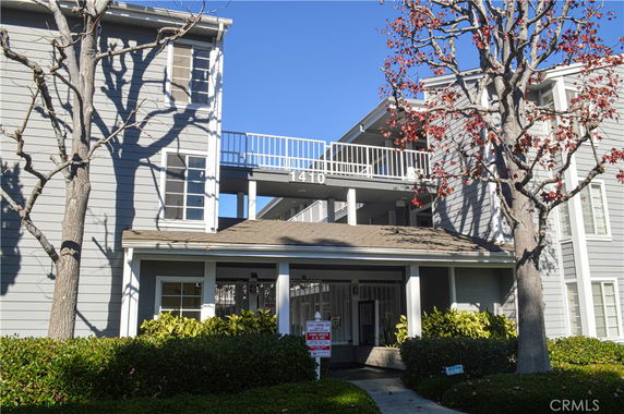 Front view of a multi-story building with balconies and a central entrance.