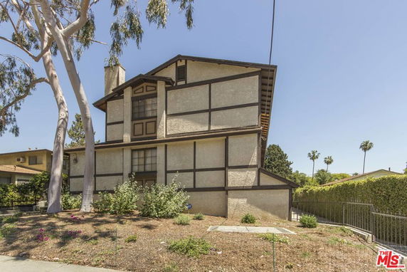 Front view of a multi-story house with a rustic design.