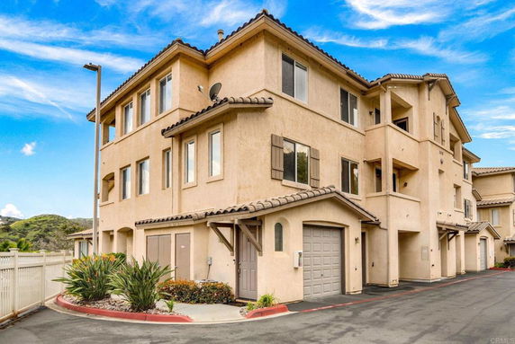 Front view of a multi-story residential building with garages.