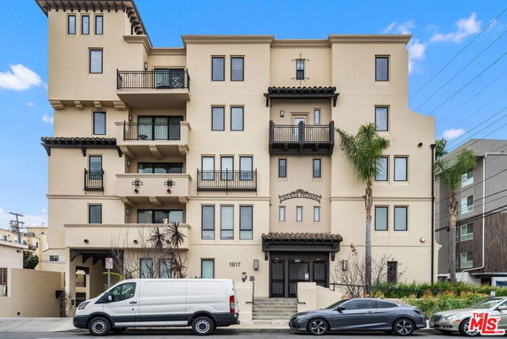Front view of a multi-story apartment building with balconies.