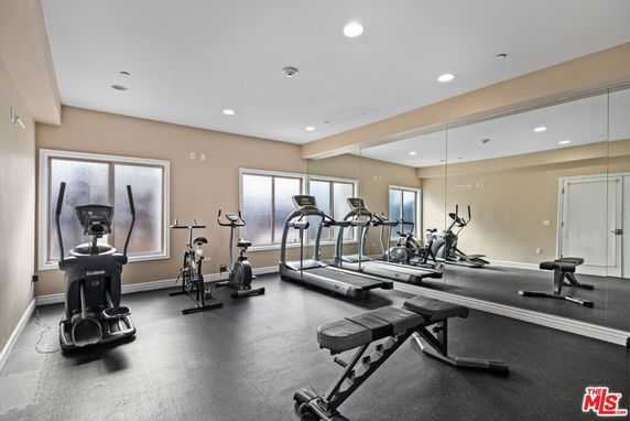 Exercise room with gym equipment including treadmills and stationary bicycles.