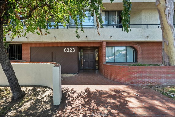 Front view of a building with a numbered entrance and brick facade.
