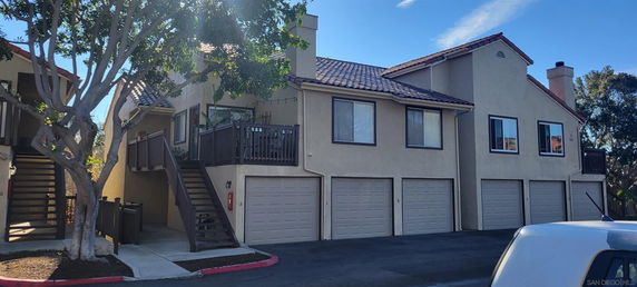 Front view of a multi-story residential building with multiple garages.