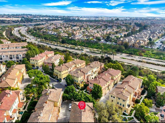 Aerial view of residential area with multiple houses and surrounding landscape.