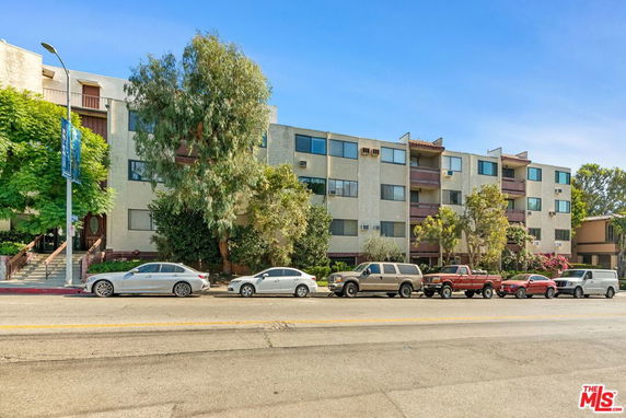 Front view of a multi-story apartment building with balconies.