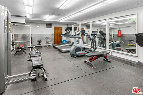 Indoor gym area with exercise equipment and large mirrors on the wall.